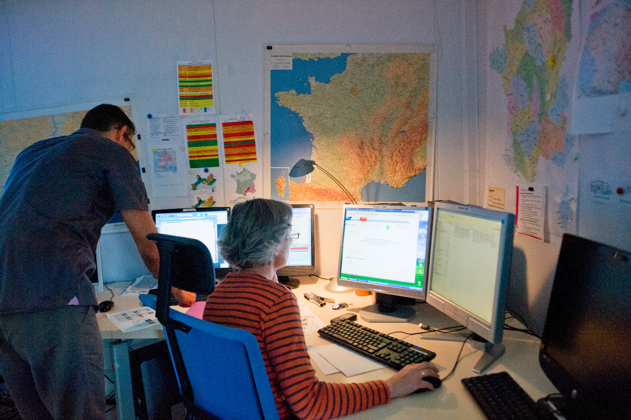 Photo montrant deux prévisionnistes de crues dans une salle opérationnelle du Schapi.