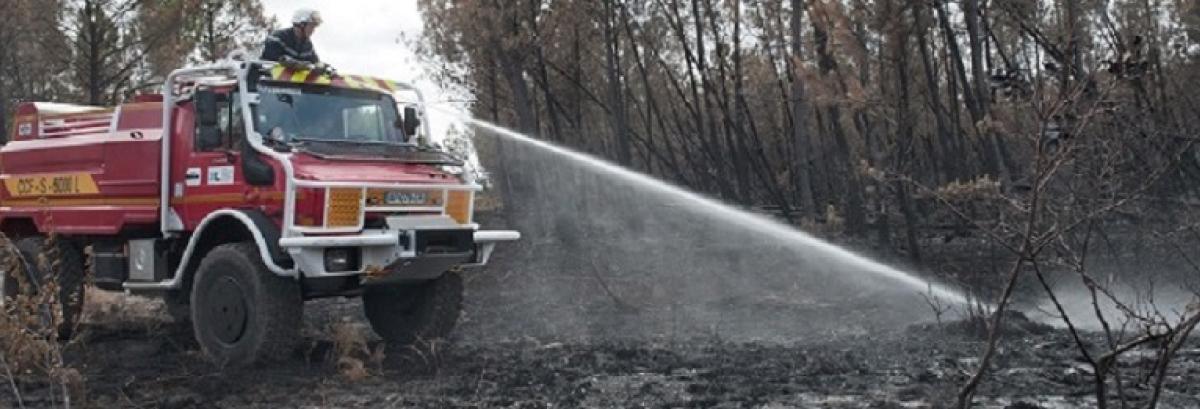 Camion de pompier éteignant un feu de forêt
